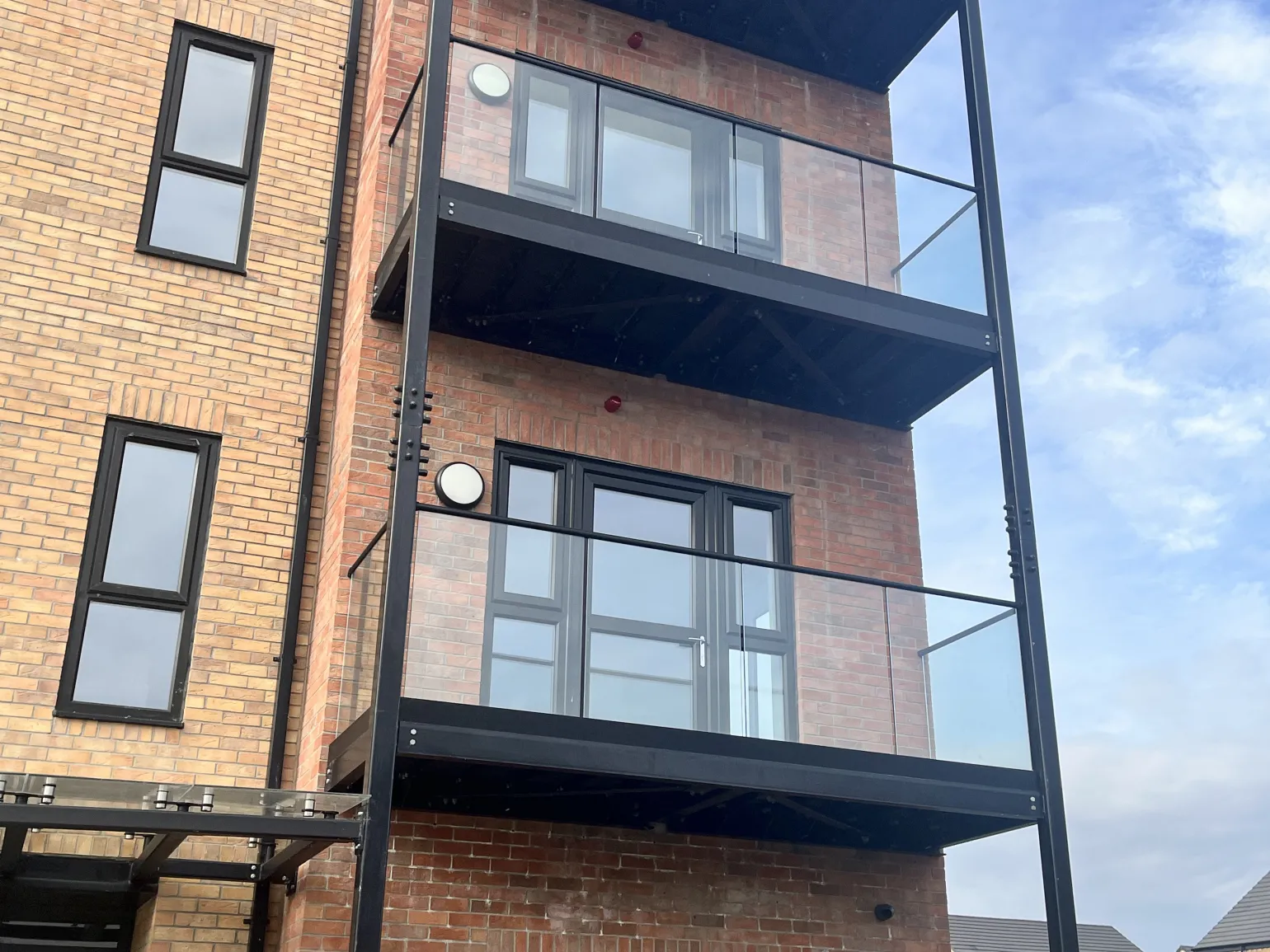 Each balcony features an EazyFit 1.5kN glass balustrade system from BM Architectural. These pre-drilled aluminium base channels are finished in a bold, anodised, black finish and complemented by matching black handrails.

An EazyFit 1.5kN system is a fully tested, glass fitting solution to BS 6180, designed to accommodate loads up to 1.5kN/m and suitable for providing fall protection in both residential and commercial applications.
