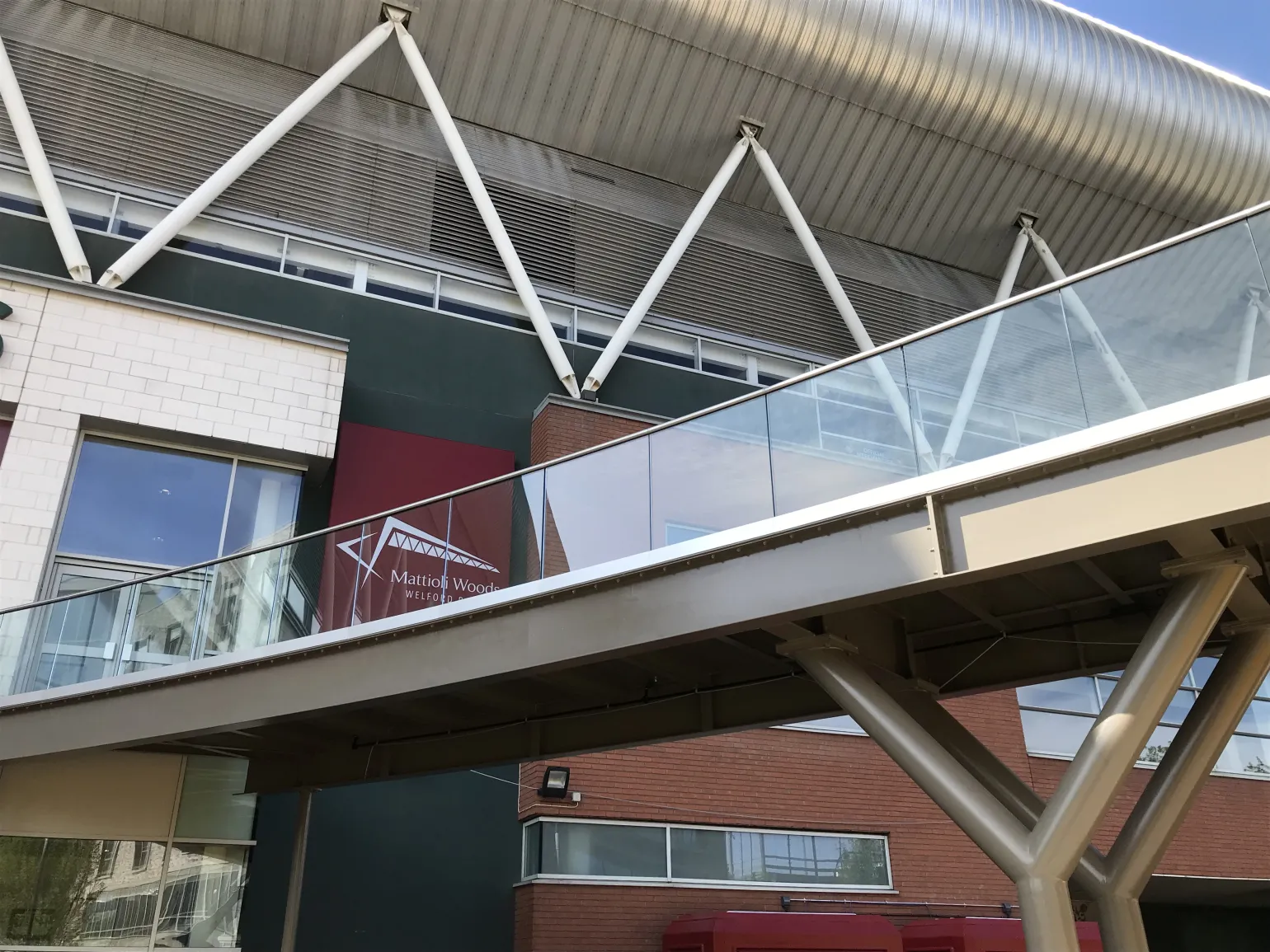 BM Architectural supplied the frameless glass balustrade installed on a raised pedestrian access route, linking the Leicester Tigers rugby stadium with an adjacent structure.

Classified as a heavy-duty application due to the footbridge experiencing very high footfall on match days and having the potential for overcrowding, a 3kN balustrade system was specified.

A stainless steel channel holds the glass panels firmly in place along their base and is fixed directly to the structure.

