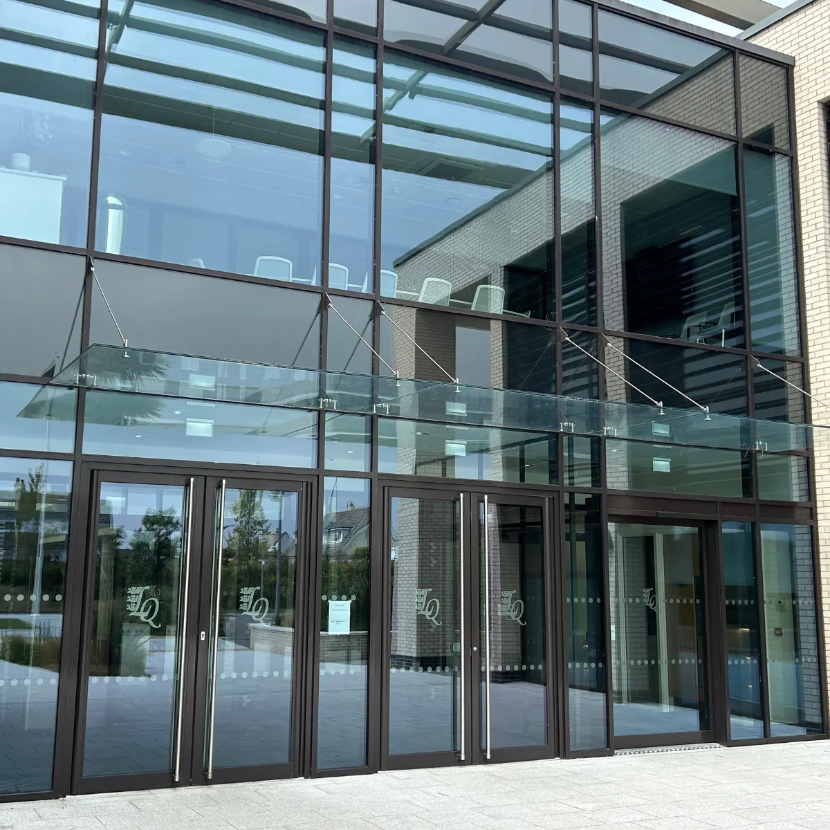 BM Architectural supplied the stainless steel glass fittings to support the glass canopy over the entrance of Les Quennevais School on Jersey.

This high performance, low maintenance canopy provides visitors with shelter from the elements. 

It is tied back to the structure from above providing unobstructed access below.  

Architecturally it was the ideal solution; it blends seamlessly into the elegant look of the broader glass façade and functions without diminishing the natural light entering the foyer.

